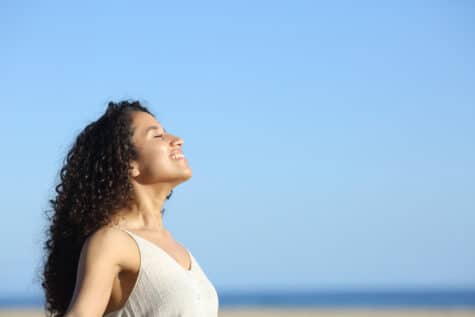 A woman smiles and accepts her emotions in recovery.